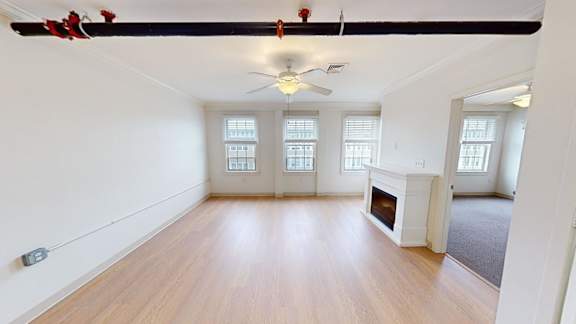 Spacious living room with fireplace and hardwood floors at Bostonian Shoe Lofts Apartments, Whitman, MA 02382