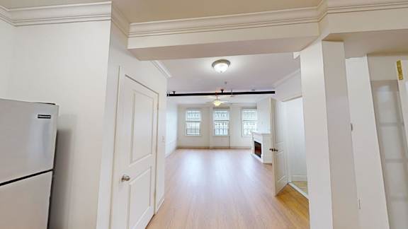 Open floor plan with hardwood flooring and ceiling fan at Bostonian Shoe Lofts Apartments, Whitman