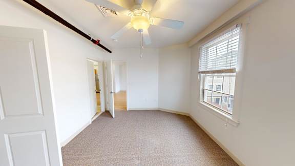 Empty bedroom with vaulted ceiling and ceiling fan at Bostonian Shoe Lofts Apartments, Massachusetts