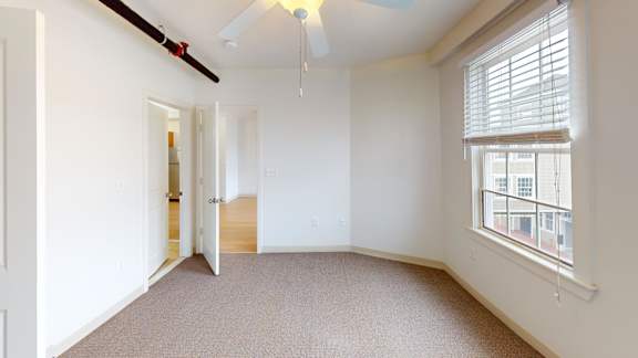 Bedroom with window blinds and ceiling light fixture at Bostonian Shoe Lofts Apartments, Whitman, 02382