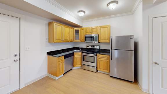 Kitchen with stainless appliances and black countertops at Bostonian Shoe Lofts Apartments, Whitman, Massachusetts