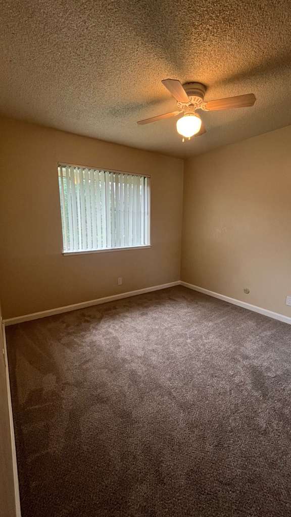 Room with a ceiling fan and carpeted floor at Vacaville Park Apartments, California
