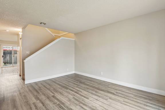 A room with a wooden floor and a staircase.