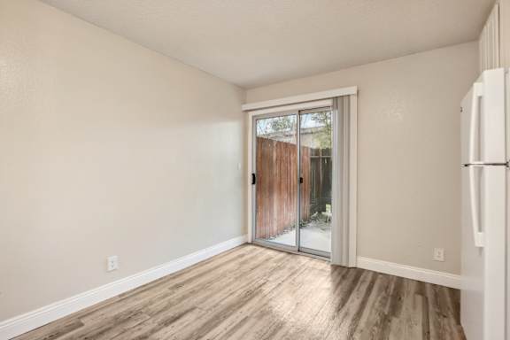 A room with a sliding glass door leading to a backyard.