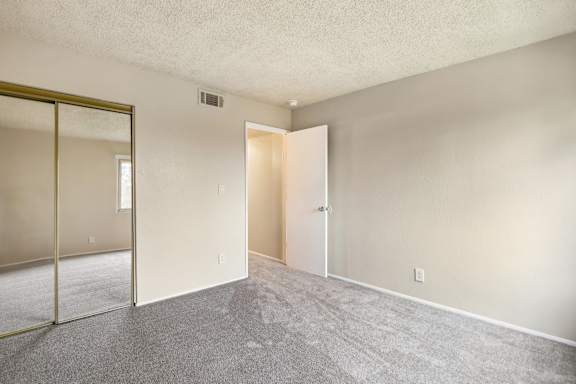 A room with a carpet floor and a white door.