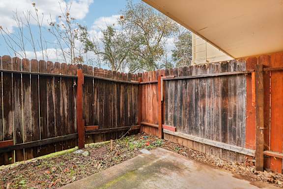 A brown wooden fence with a concrete slab in the middle.