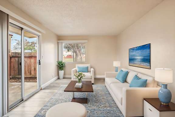 A living room with a white couch, a coffee table, and a painting on the wall.