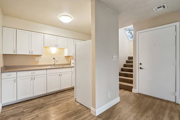 A kitchen with white cabinets and a countertop.