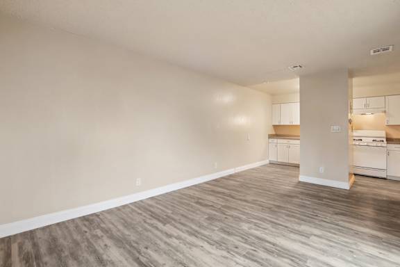 A room with wooden flooring and white walls.
