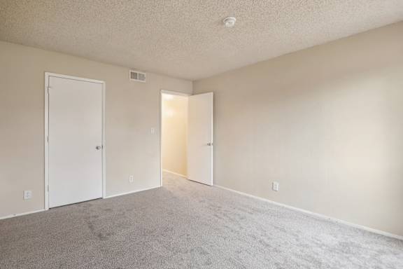 A room with two doors and carpeted floor.