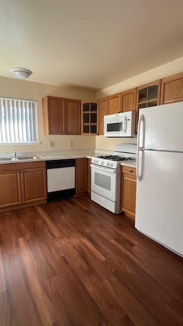 Kitchen with wooden floors and white appliances at Vacaville Park Apartments, California , 95687