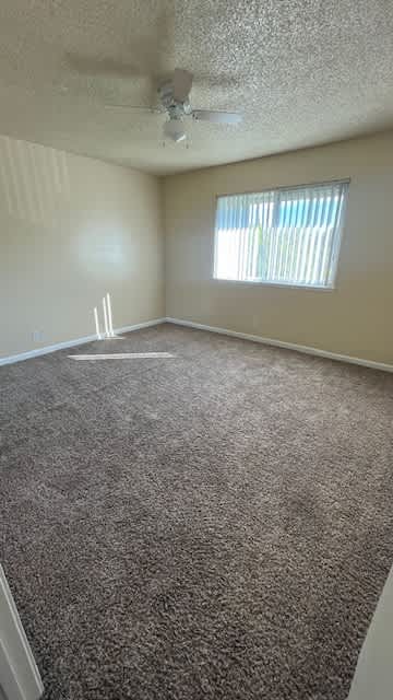Carpeted floor and a ceiling fan at Vacaville Park Apartments, Vacaville, CA