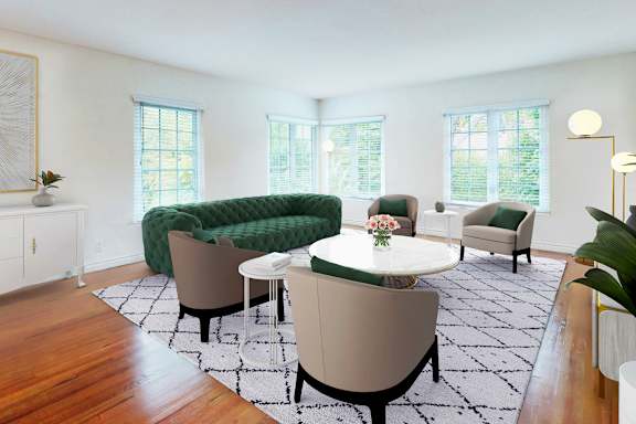 A living room with a green sofa and a white table.