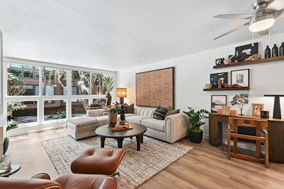 A living room with a brown leather chair and a white couch.