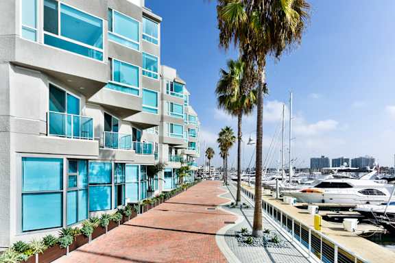 A marina with boats and a building with balconies. at Esprit Apartments, Marina del Rey, California