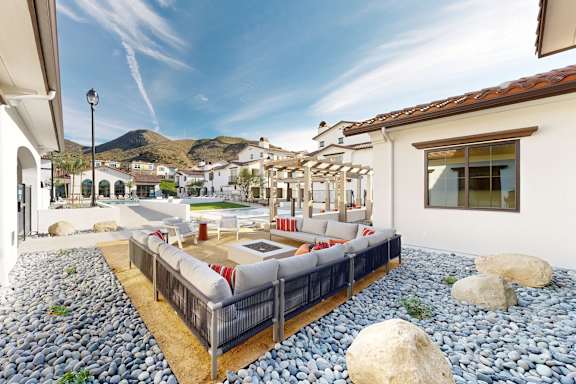 A patio with a couch and a table with a mountain in the background at The Villas at Anacapa Canyon, Camarillo