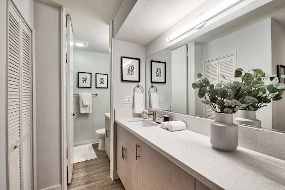 A bathroom with a white counter and a mirror at The Meadows Apartments, Culver City , CA