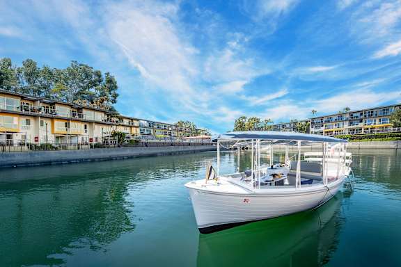 A white boat is docked in a greenish body of water.