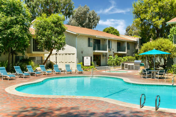 a swimming pool with a house in the background at Village Pointe Apartments, California