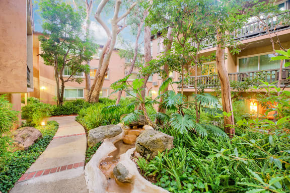 a garden with trees and rocks and a stream  at Casa Granada, Los Angeles