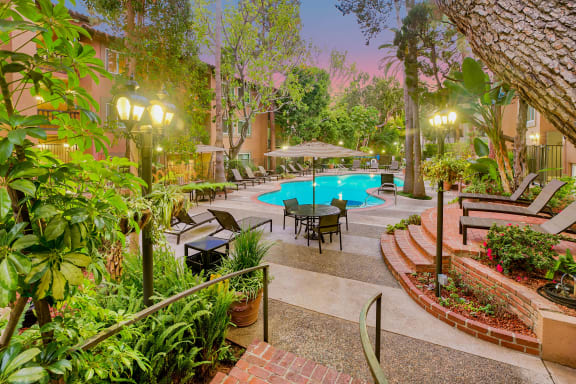 a backyard with a swimming pool and a patio with tables and chairs at Casa Granada, Los Angeles, CA