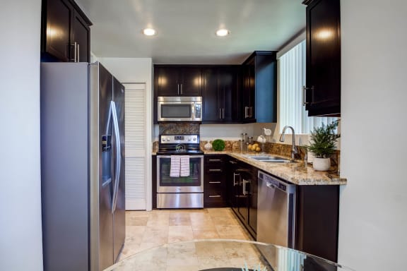 a kitchen with stainless steel appliances and black cabinets  at L&#x27;Estancia, Studio City, California