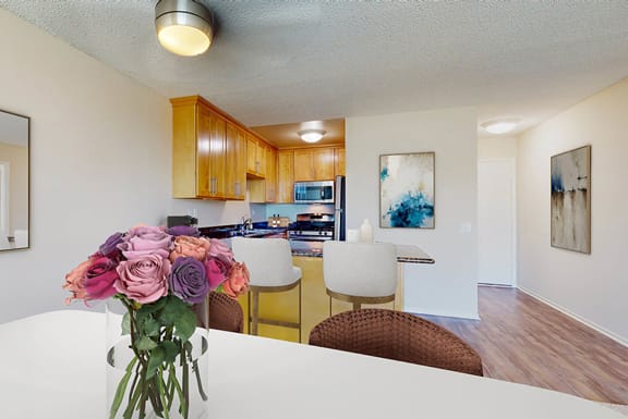 a dining room table with a vase of flowers    and a kitchen at Marina Harbor, Marina del Rey, CA