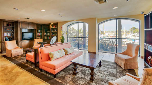 a living room with a couch and a table     and large windows  at Marina Harbor, Marina del Rey, CA
