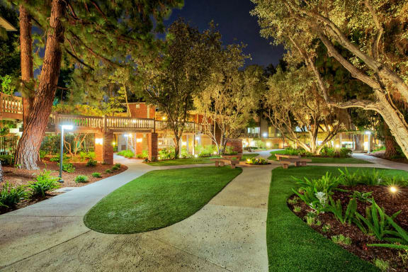 a yard with grass and trees at night at The Meadows Apartments, Culver City, CA