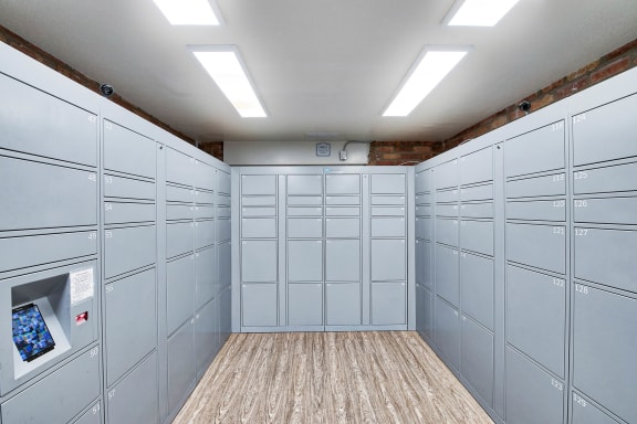 a bunch of white lockers in a room with a wood floor at The Meadows Apartments, Culver City , CA