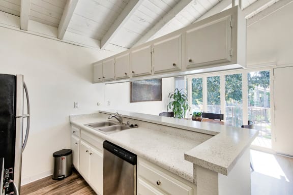 a kitchen with white cabinets and a large window  at Mediterranean Village Costa Mesa, California, 92626