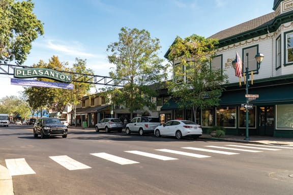 a city street with cars parked in front of a restaurant at Pleasanton Place, California, 94566