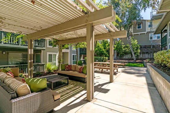 a covered patio with furniture and a pergola at Pleasanton Glen Apartments, Pleasanton