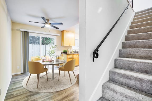 a dining room with a table and chairs next to a staircase  at Pleasanton Place, Pleasanton, CA, 94566