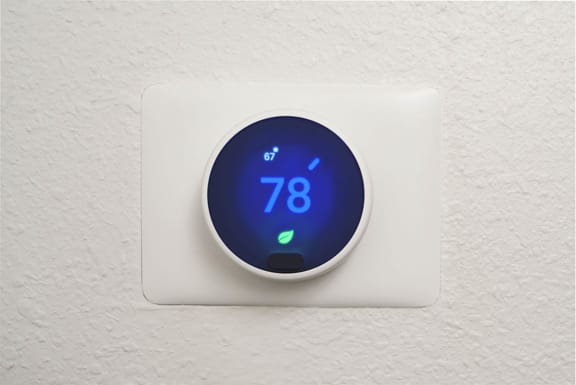 a digital thermostat on a wall with the number 78 on it
