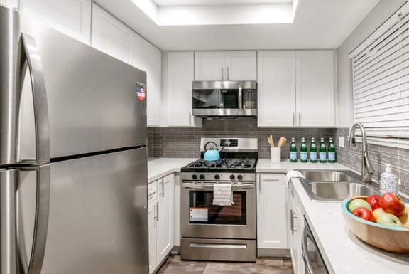 a kitchen with stainless steel appliances and white cabinets