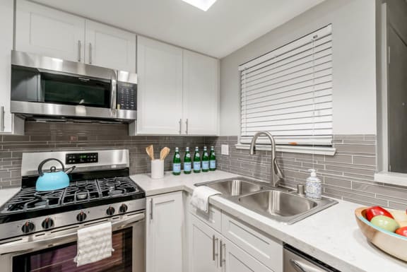 a modern kitchen with stainless steel appliances and white cabinets