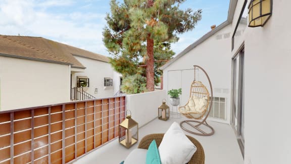 a patio with a swing and a chair on a balcony at Sendero Huntington Beach, Huntington Beach, 92647