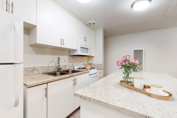 a kitchen with white cabinets and granite counter tops  at Casa Granada, California