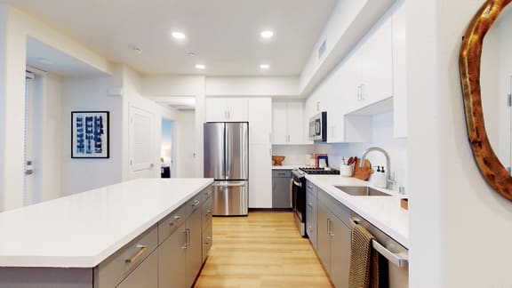 a large kitchen with stainless steel appliances and white counter tops at The Villas at Anacapa Canyon, Camarillo, CA