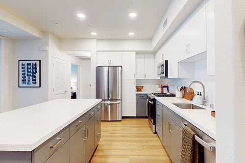 a large kitchen with stainless steel appliances and white counter tops at The Villas at Anacapa Canyon, Camarillo, California