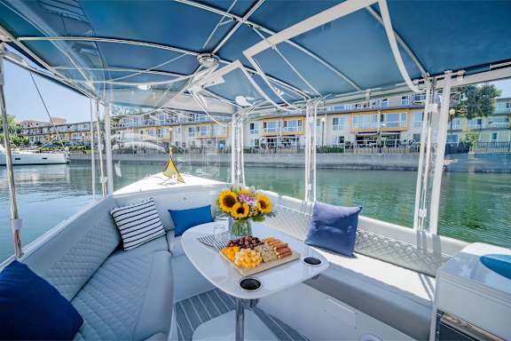 The interior view of a Duffy Boat, with snacks and pillows