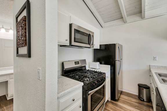 A kitchen with a black stove top oven and a black refrigerator.
