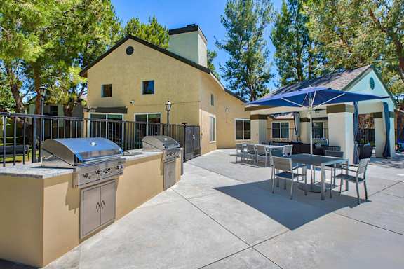 A patio with a table and chairs is surrounded by a fence and a house at Mountain Vista, Victorville, CA