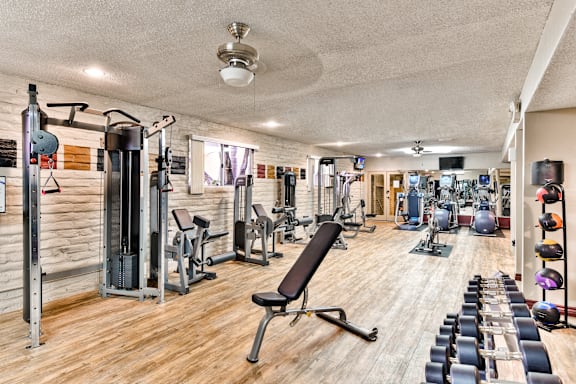 A well-equipped gym with a variety of exercise machines and weights at Mediterranean Village West Hollywood, California