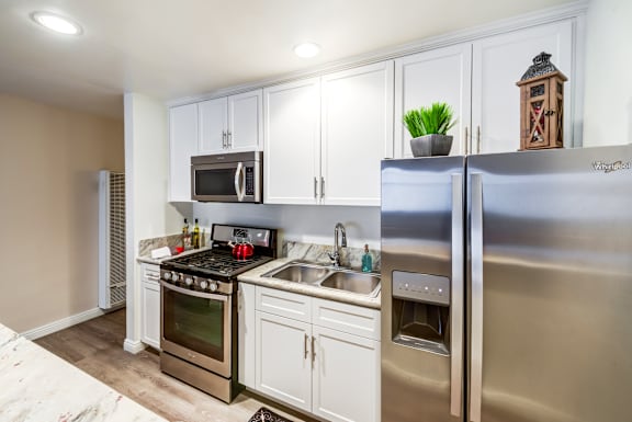 A kitchen with a stove, oven, refrigerator, and microwave at Mediterranean Village West Hollywood, California