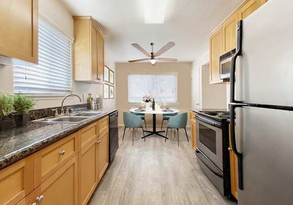 A kitchen with wooden cabinets and a black refrigerator.