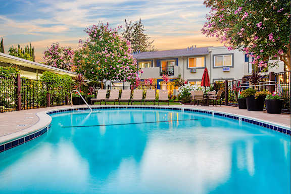 A swimming pool surrounded by a fence and trees at Pleasanton Place, Pleasanton, CA, 94566
