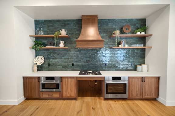 A kitchen with a blue brick wall and wooden cabinets at The Villas at Anacapa Canyon, Camarillo