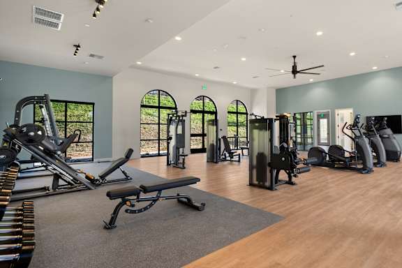 A gym with a variety of equipment including treadmills, weights, and a bench at The Villas at Anacapa Canyon, Camarillo